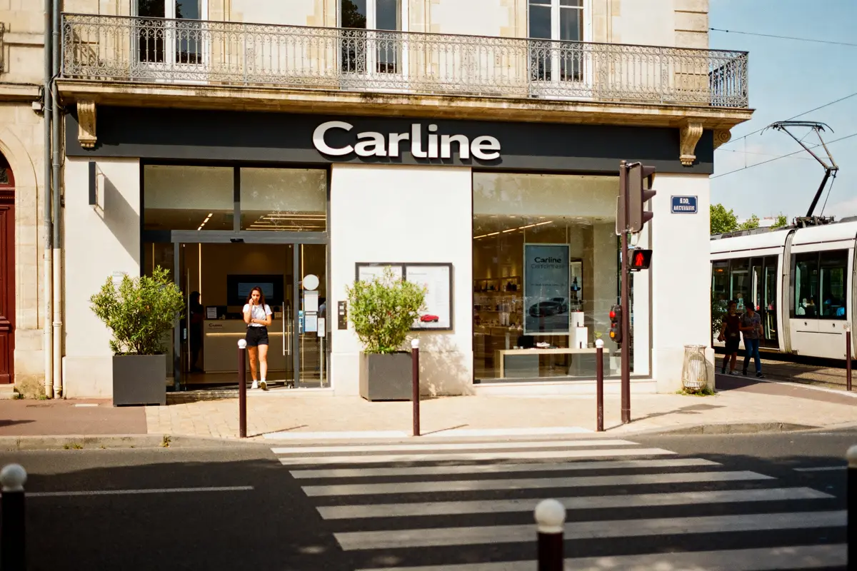 Vitrine de Carline à Caen avec piéton sur un passage clouté devant le magasin