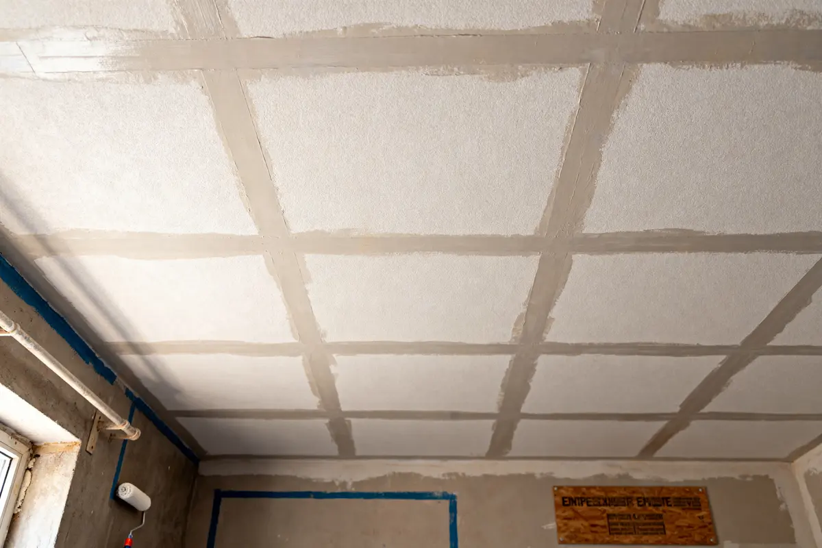 Plafond en préparation avec un schéma pour peindre efficacement un plafond en carreaux blancs
