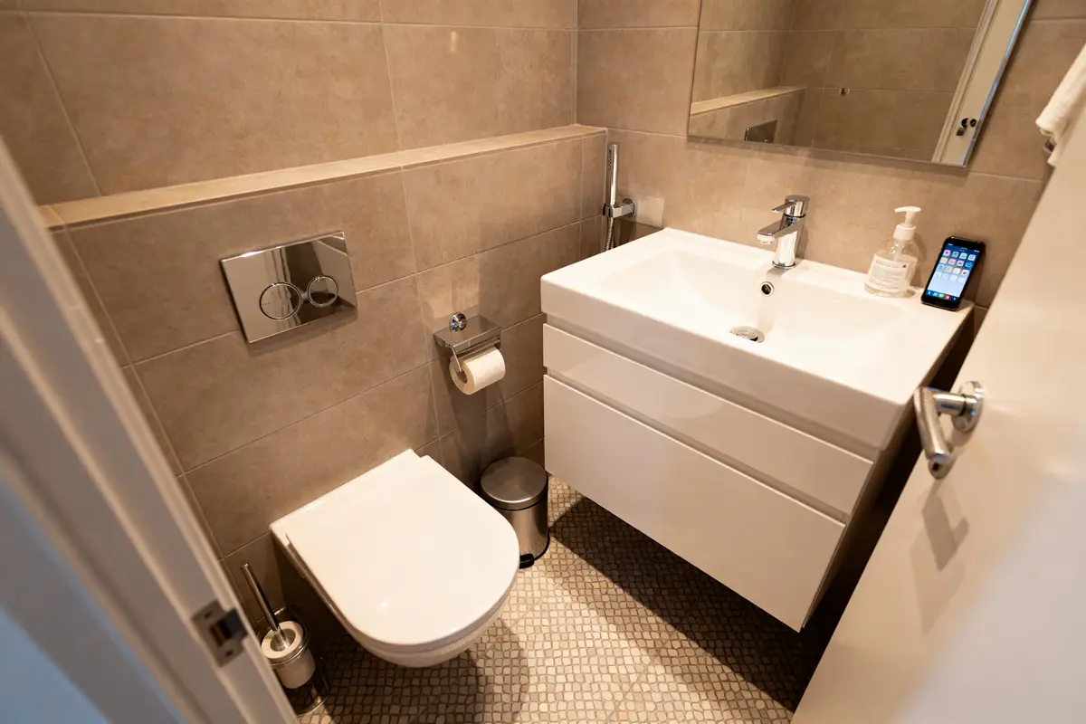 Petite salle d'eau de 3m2 avec lavabo blanc, toilettes et carrelage moderne