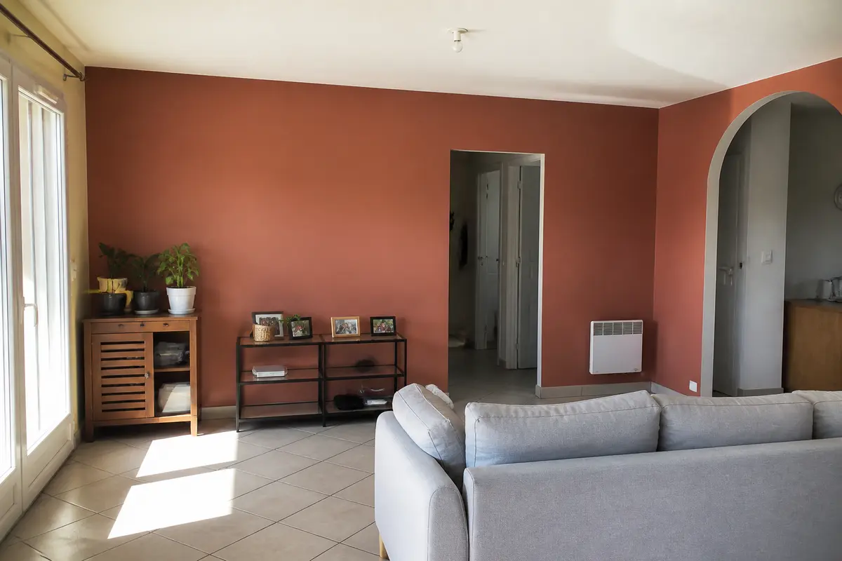 Salon lumineux avec mur terracotta, meubles modernes et batievol pour peinture intérieure efficace
