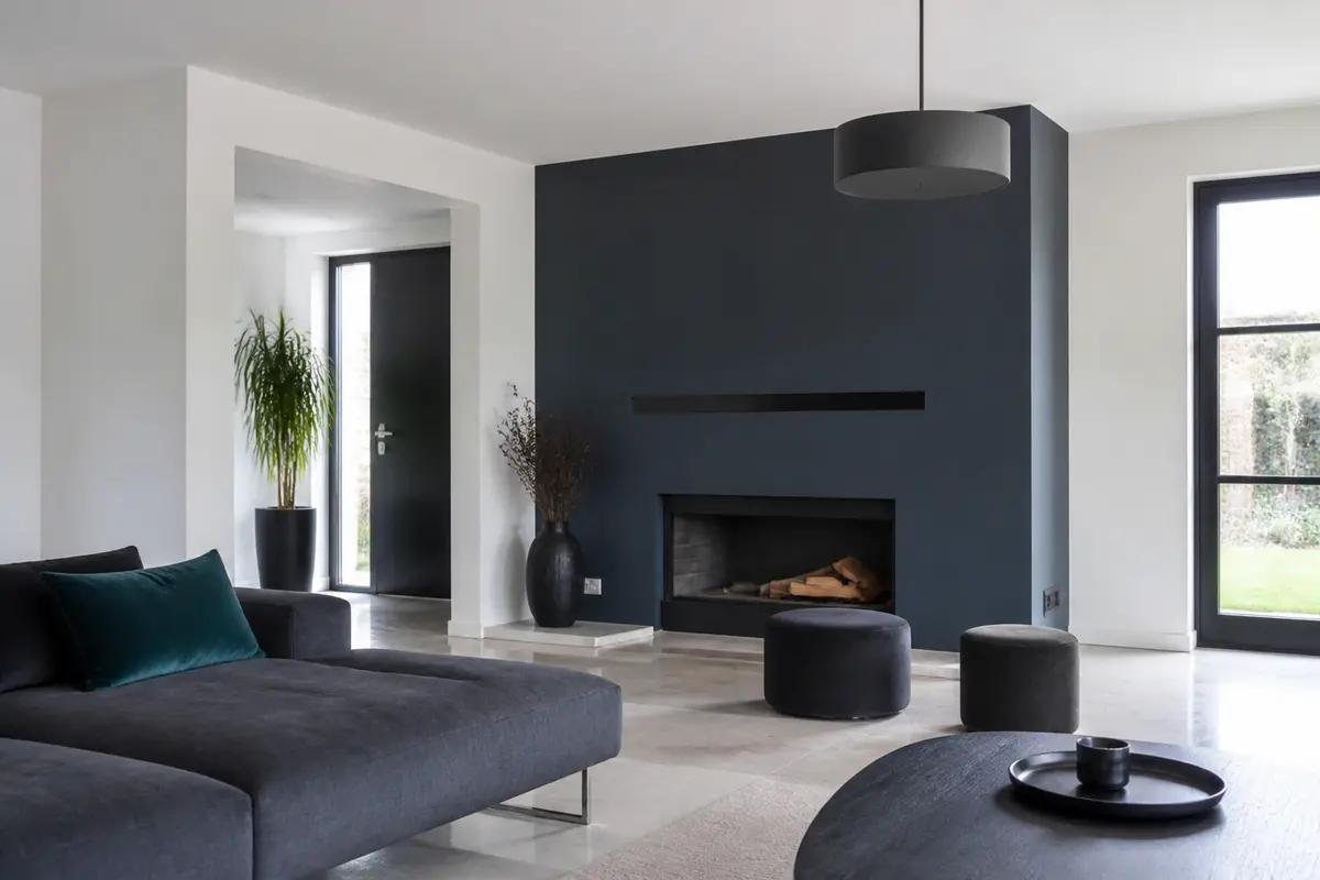 Salon moderne avec canapé et mur en couleur charcoal adjacents à une cheminée design