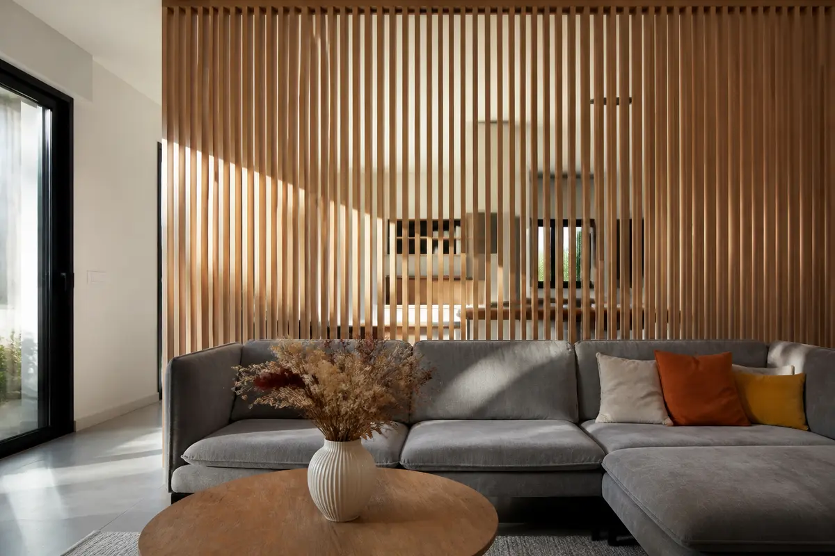 Salon moderne avec canapé gris et séparation en bois, idée déco avec tasseaux élégante