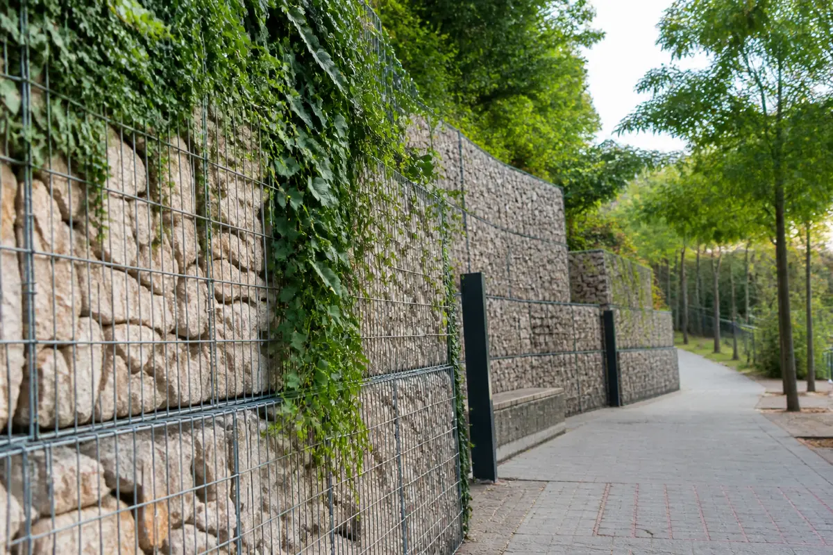 Mur de gabions à Paris entouré de végétation dans un espace urbain aménagé