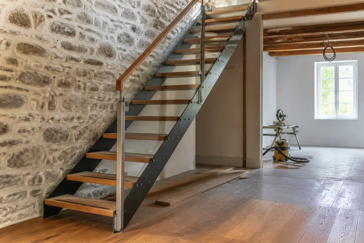 Escalier intérieur moderne en bois et métal dans maison rénovée par Aquitaine Travaux Rénovation